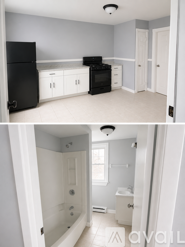A black refrigerator and oven in a kitchen with white cabinets.