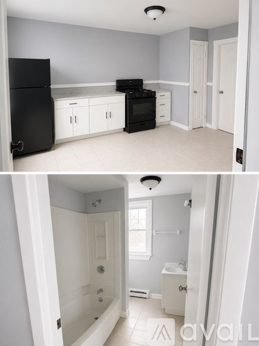 A black refrigerator and oven in a kitchen with white cabinets.