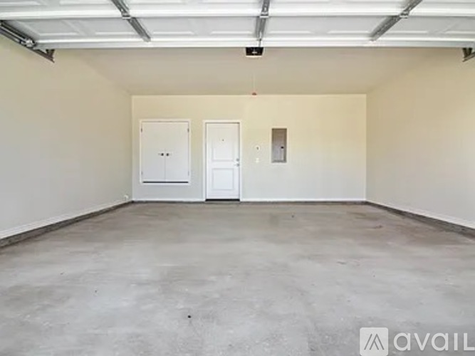 A large empty room with two doors and a window.
