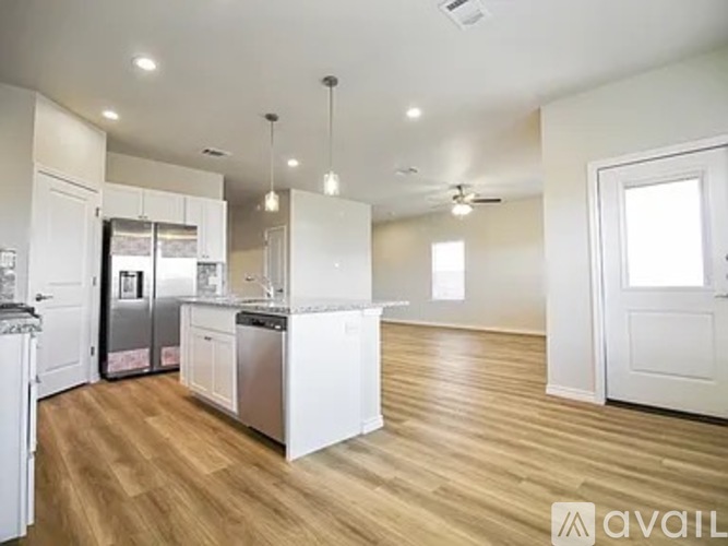 A kitchen with white cabinets and a wooden floor.