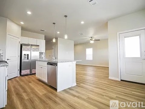 A kitchen with white cabinets and a wooden floor.