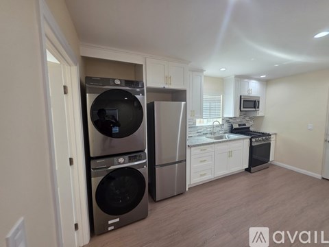 A kitchen with a washer and dryer stacked on top of each other.