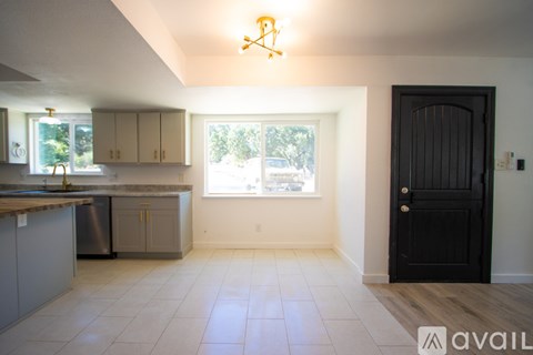 A kitchen with a sink, cabinets, and a window.