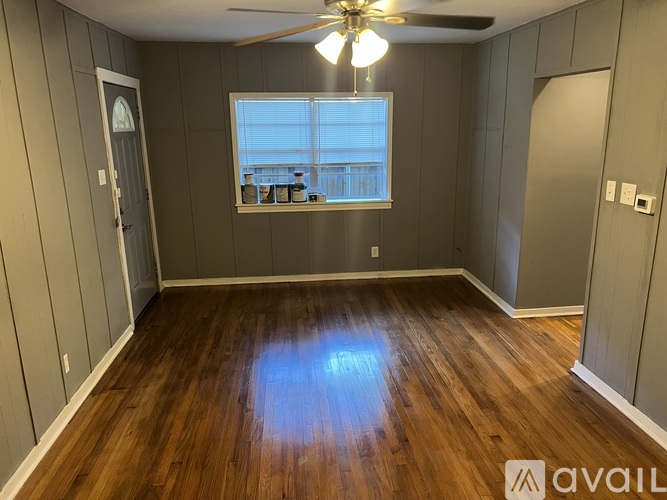 A room with wooden floors and a window with blinds.