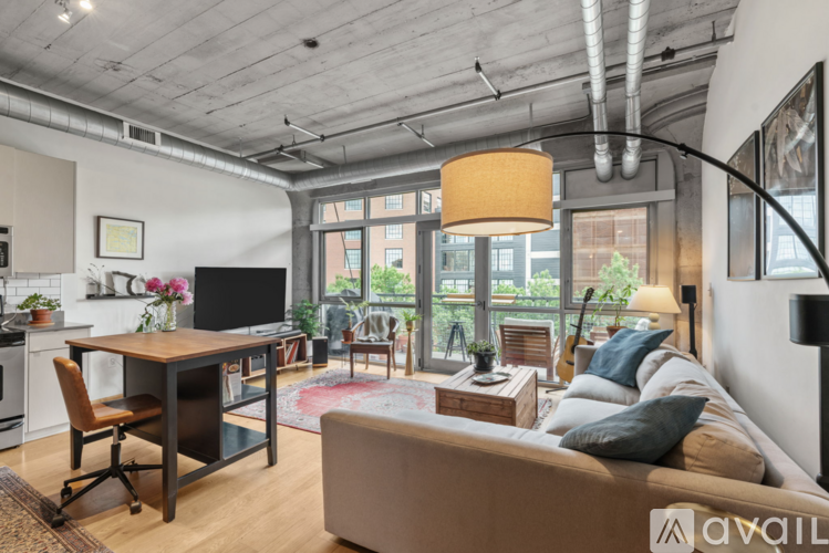 A modern living room with a brown couch and a wooden desk.