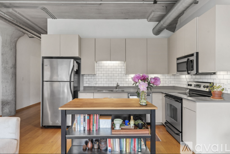 A kitchen with a refrigerator, oven, and microwave.