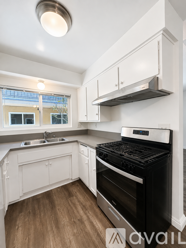 A modern kitchen with a black stove top oven.