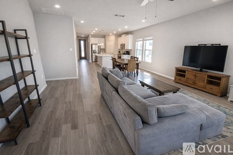 A living room with a grey sofa and wooden flooring.
