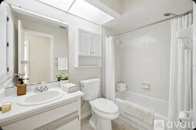 A modern kitchen with white cabinets and a tiled floor.