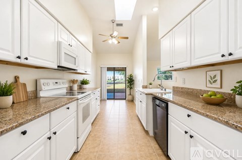 A modern kitchen with white cabinets and a tiled floor.