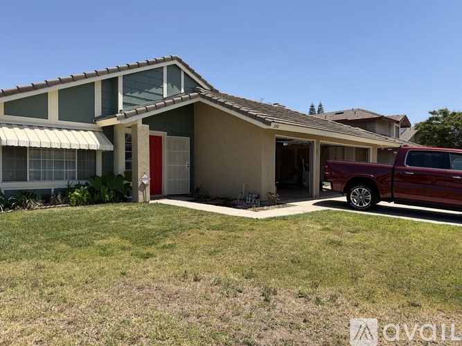 A house with a red car parked in front.