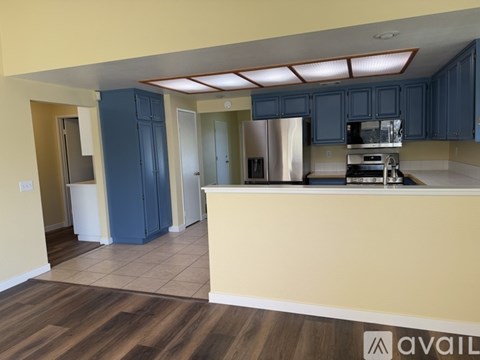 A kitchen with blue cabinets and a white countertop.