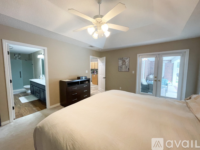 A bedroom with a large bed and a ceiling fan.