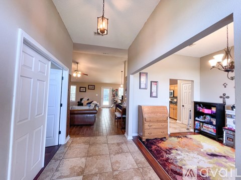 A living room with a rug and a television.