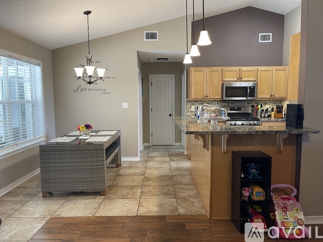 A kitchen with a dining table and a chandelier.