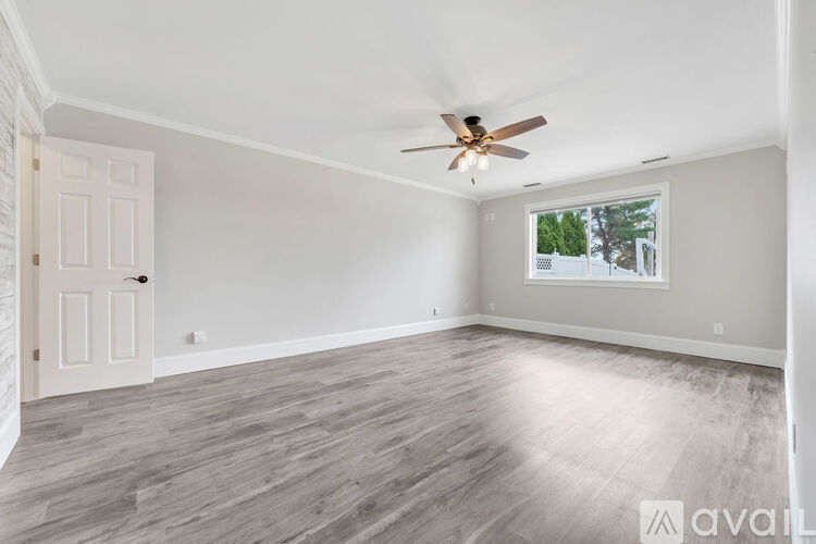 A spacious room with a ceiling fan and a window.