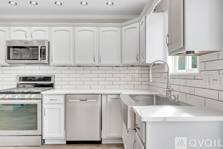 A kitchen with white cabinets and appliances.