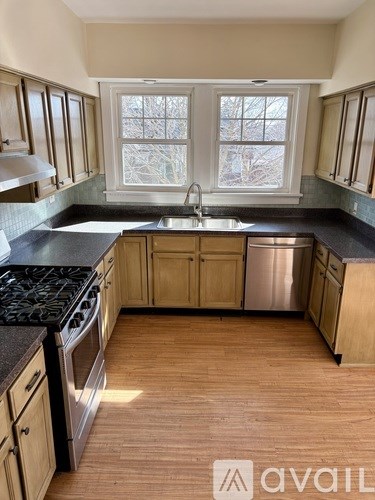 A kitchen with wooden cabinets and a black countertop.