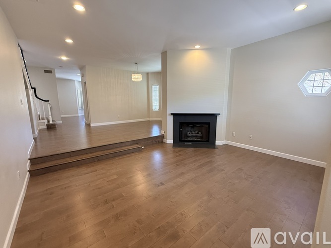 A spacious living room with a fireplace and hardwood flooring.