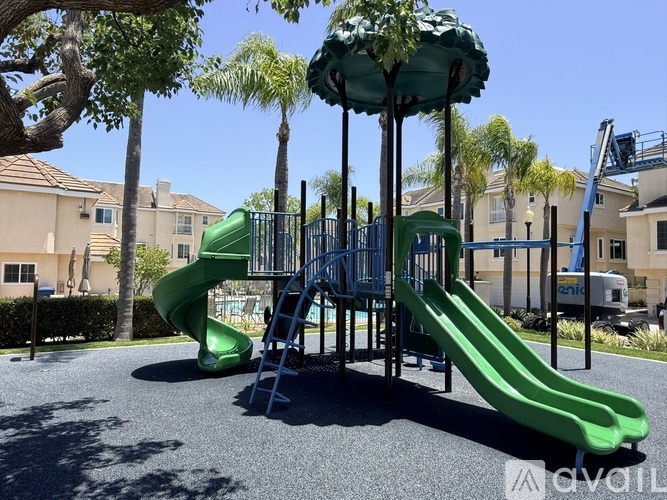 A playground with a green slide and a blue structure.