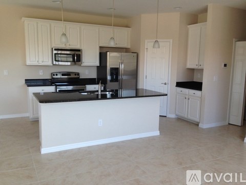 A kitchen with a white island and stainless steel appliances.