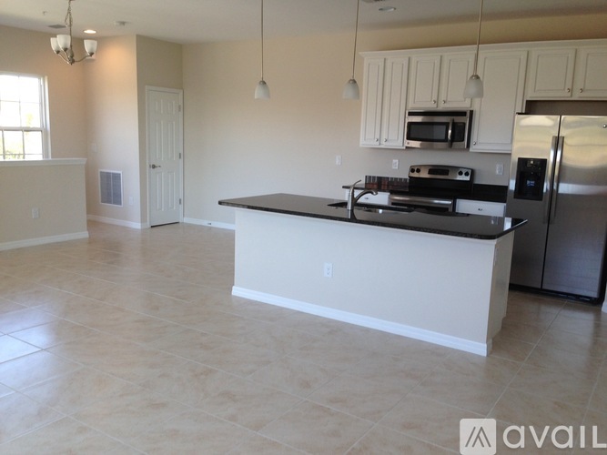A kitchen with a black countertop and stainless steel appliances.