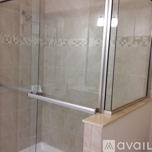 A glass shower door with a white handle.