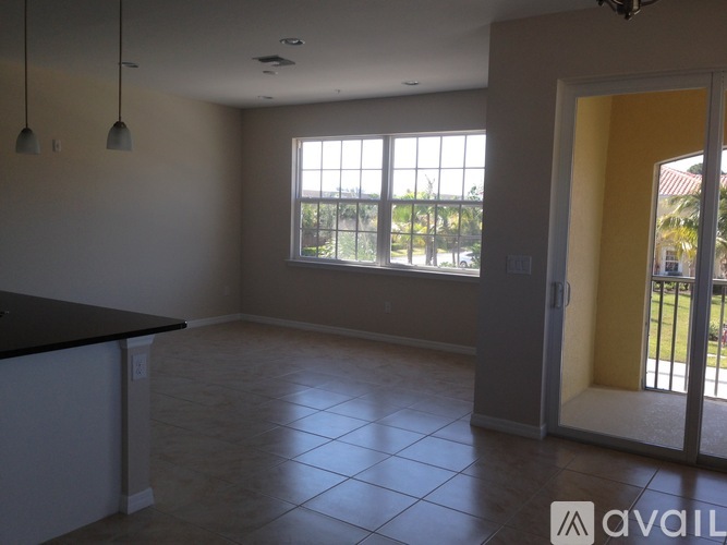 A spacious room with a large window and a tiled floor.