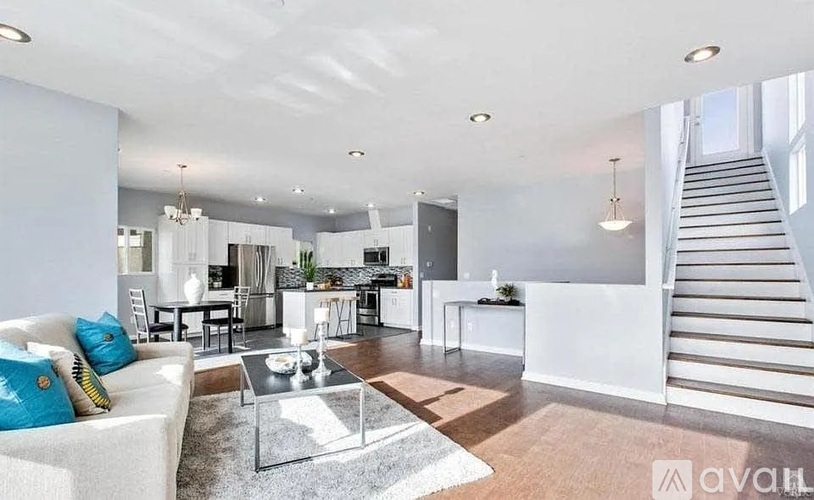 A spacious living room with a staircase leading to the upper floor.