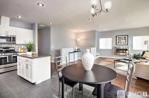 A modern kitchen with a dining table set in the middle.
