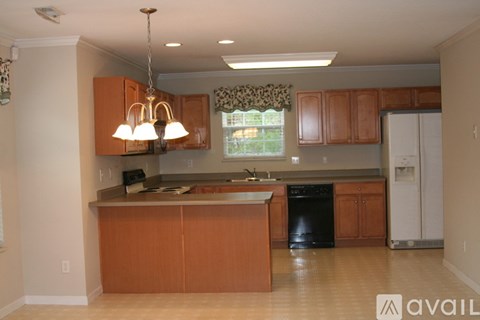 A kitchen with wooden cabinets and a black dishwasher.