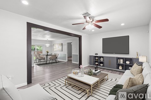 A living room with a white couch and a black and white striped rug.