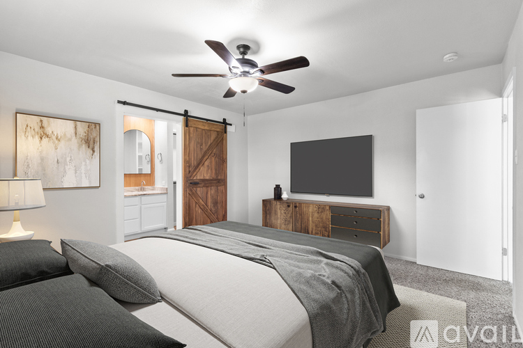 A bedroom with a bed, a dresser, and a ceiling fan.