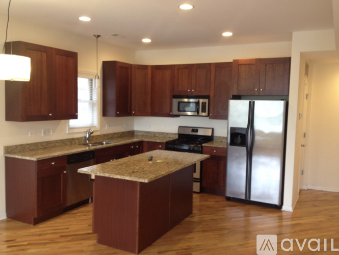 A kitchen with brown cabinets and a granite countertop.