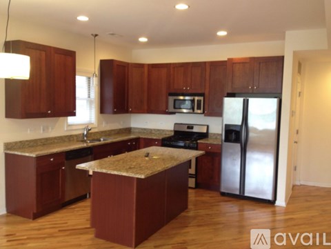 A kitchen with brown cabinets and a granite countertop.
