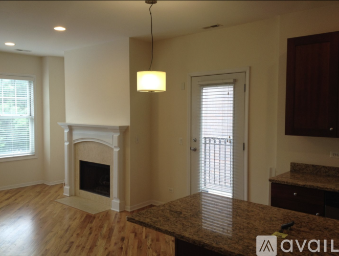 A living room with a fireplace and a door leading to a balcony.