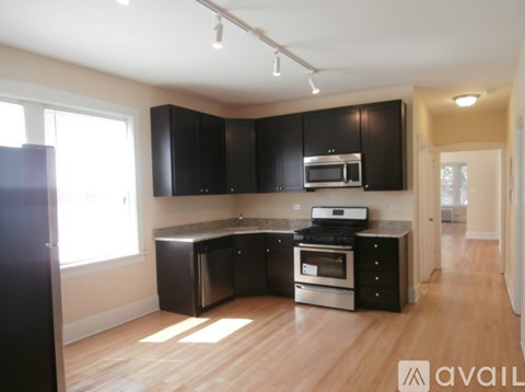 A kitchen with black cabinets and stainless steel appliances.