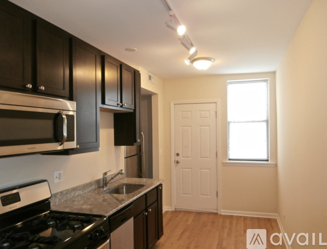 A kitchen with black cabinets and a white stove top oven.