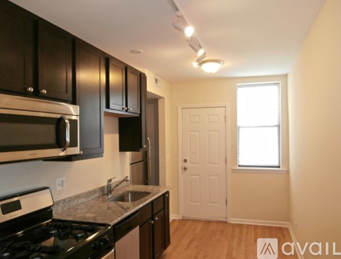 A kitchen with black cabinets and a white stove top oven.