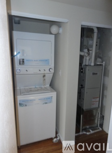 A white dishwasher is in a kitchen next to a wall.