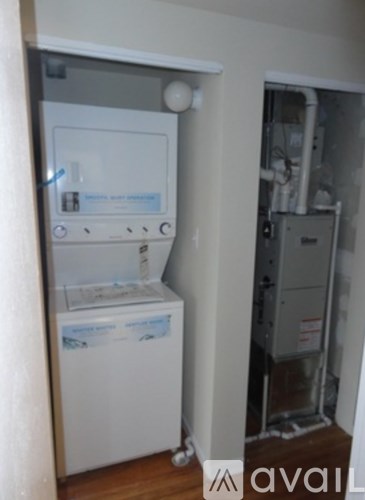 A white dishwasher is in a kitchen next to a wall.