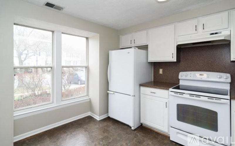 A kitchen with white appliances and brown countertops.