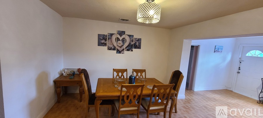 A dining room with a wooden table and chairs.
