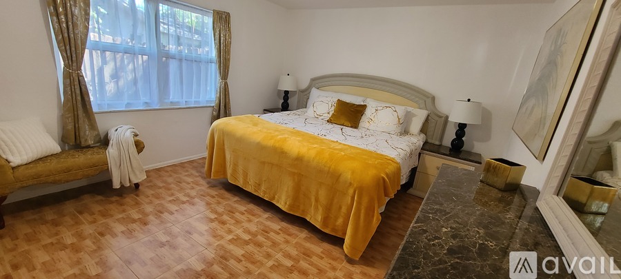 A bedroom with a large bed and a wooden bench.