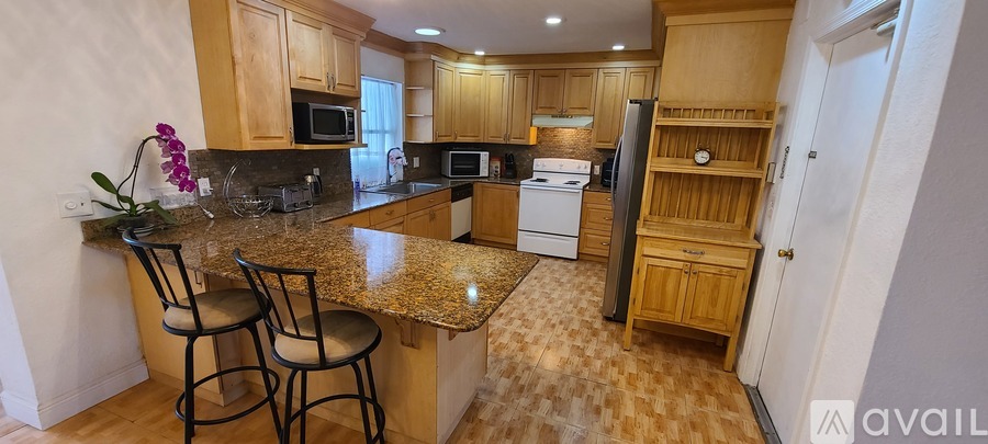 A kitchen with granite countertops and wooden cabinets.