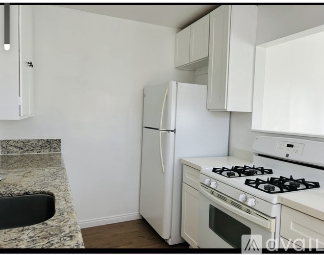 A kitchen with a white fridge, stove, and oven.