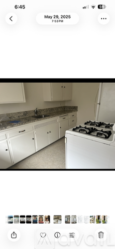 A kitchen with white cabinets and a white stove top oven.