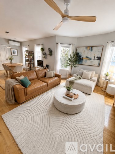 A living room with a brown leather couch and a white rug.