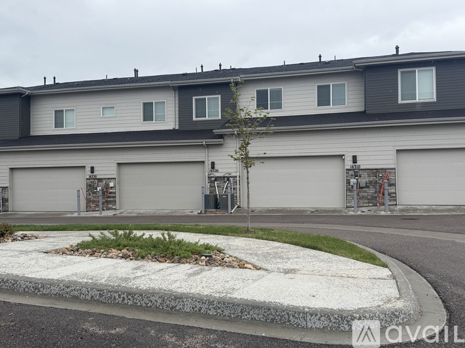 A grey building with a white and grey garage door.