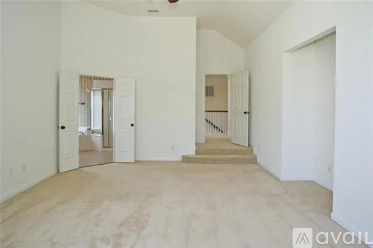 A spacious room with a staircase leading to the second floor.